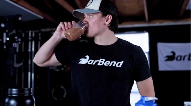 A person drinking a protein shake from a glass.
