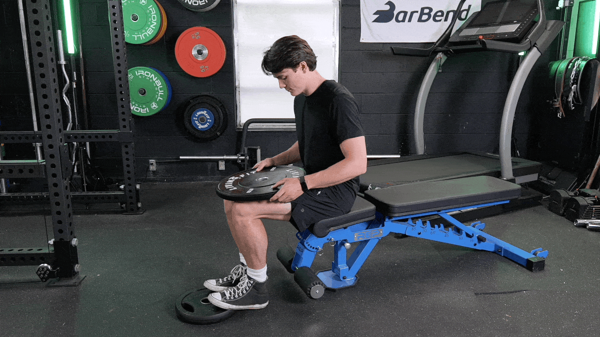 A person performing the seated calf raise exercise.