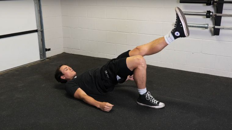 A person performing the single leg glute bridge exercise, which is similar to a The Shoulder Bridge, pilates workout.