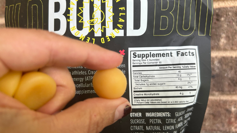 A close-up of an XWERKS Build Creatine Gummy held up against the Supplement Facts.