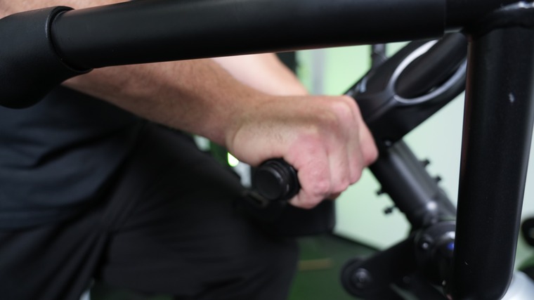 A person grips the moving handles of the Bowflex Max Trainer M6.