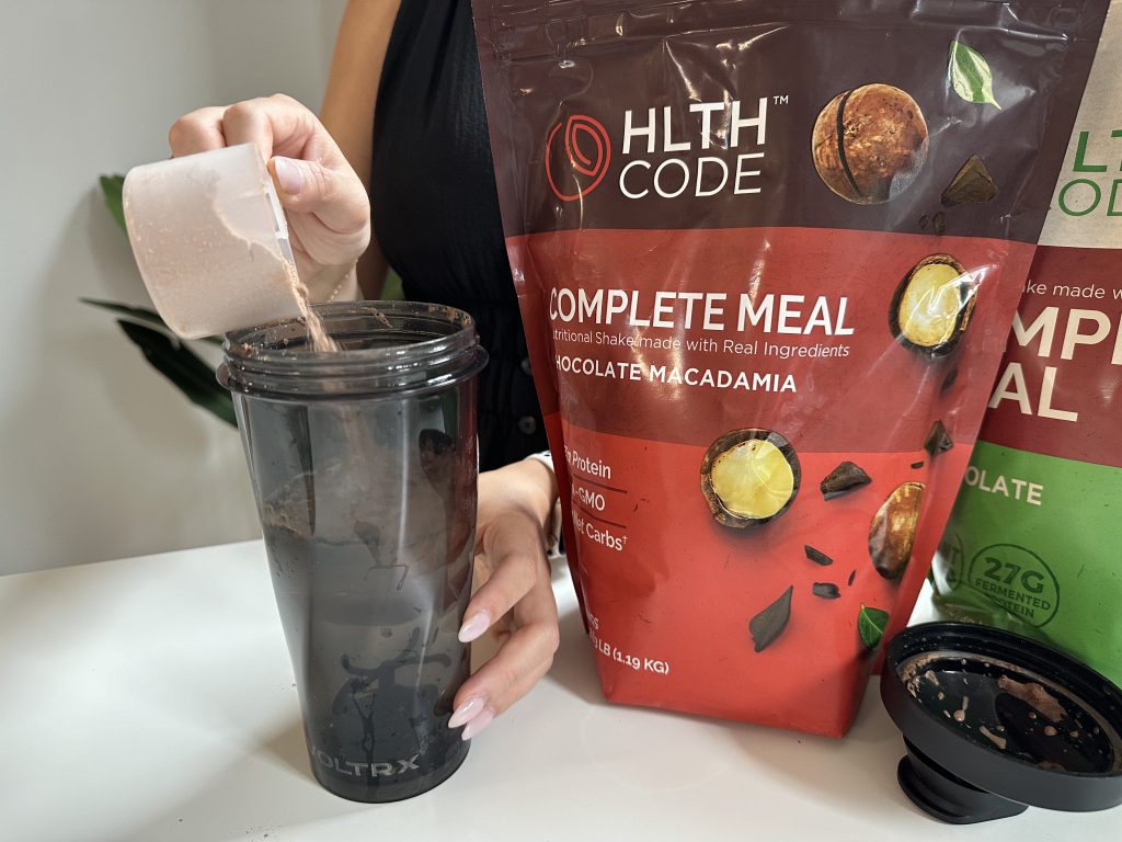 Our tester scooping the HLTH Code Meal Replacement powder into blender bottle.