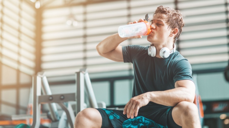 A fit person drinking a pre-workout supplements.