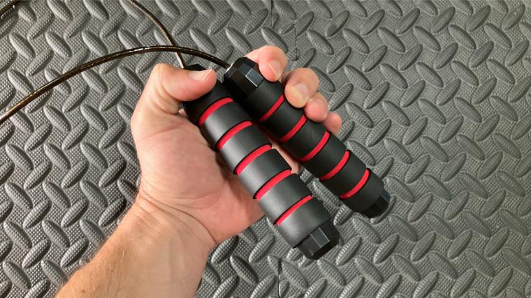 A BarBend tester holding the handles of the DEGOL Skipping Rope with Ball Bearings.