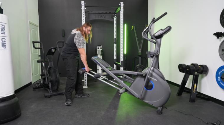 A person lifting and moving the Horizon EX-59-Elliptical.