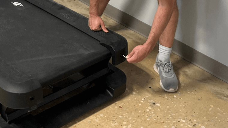 A close look at the end caps being removed from a treadmill.