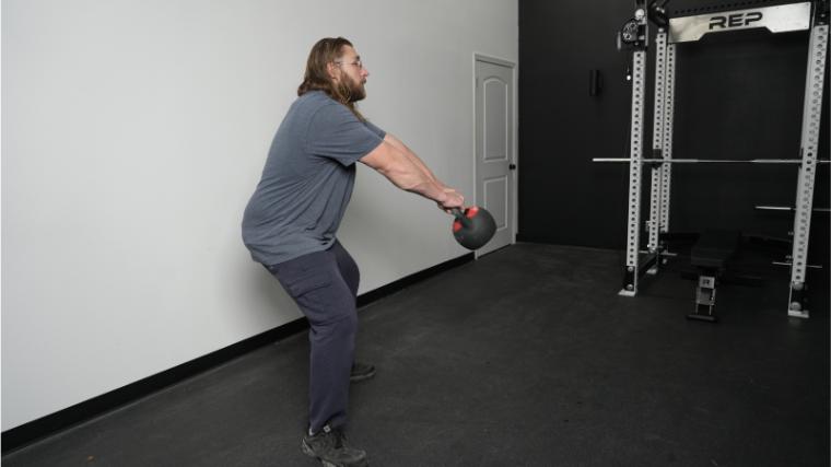 Our tester performing a kettlebell swing with the REP Fitness Adjustable Kettlebell.