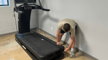 A person fixing the NordicTrack X32i treadmill.