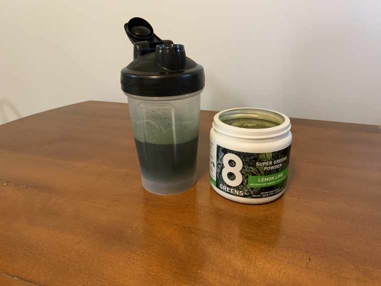 Fresh-mixed 8Greens Super Greens Powder in a shaker cup.