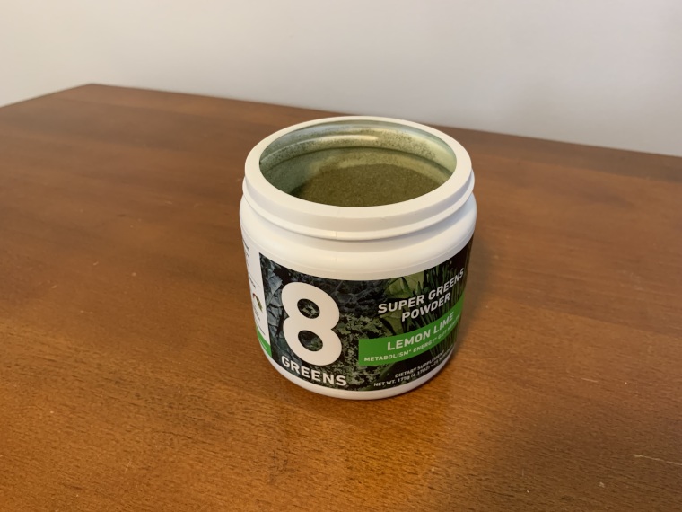 An opened tub of 8Greens Super Greens Powder.