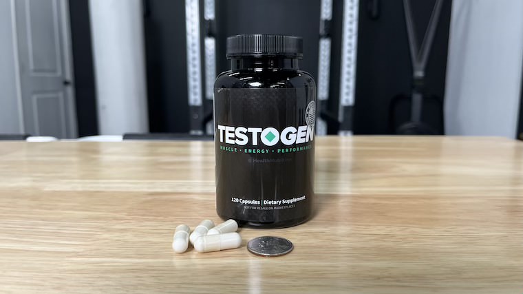 Testogen testosterone booster capsules next to a quarter.