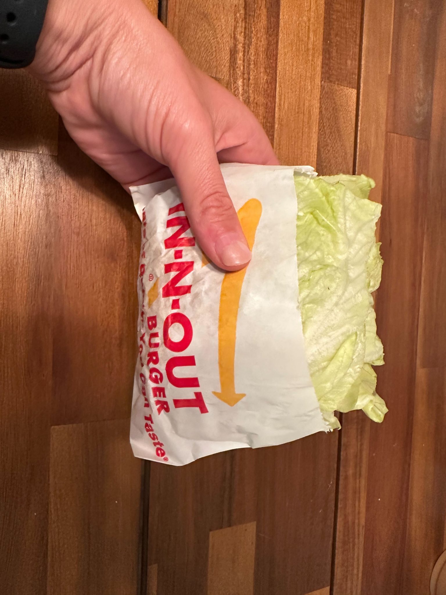 A BarBend team member holds the In-N-Out Protein-Style Hamburger.