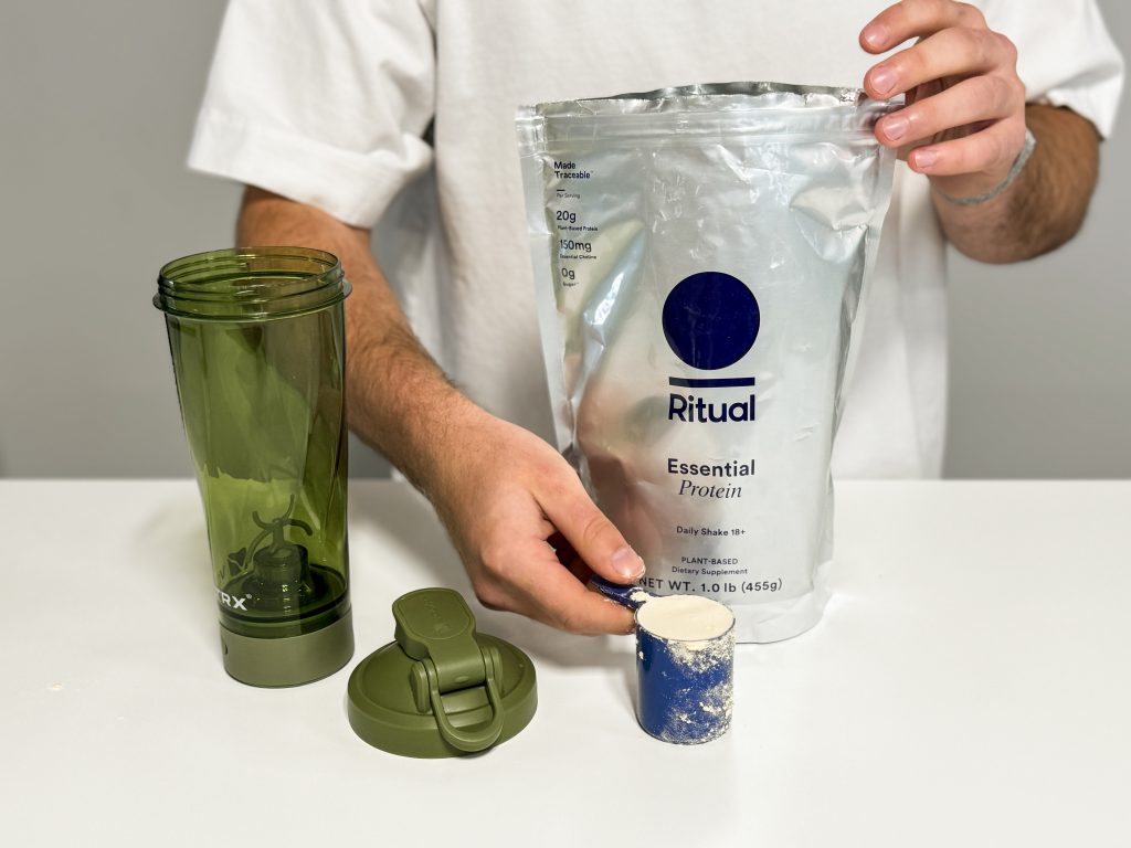 Our tester holding a scoop of Ritual Essential Protein Daily Shake 18+
