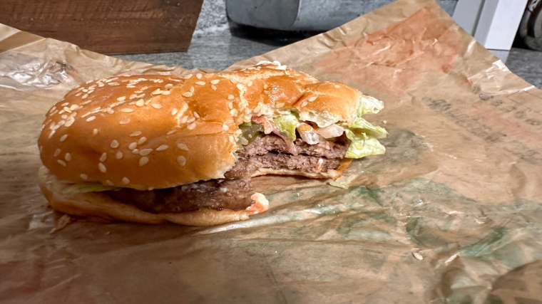 A Burger King Double Whopper with a big bite in it.