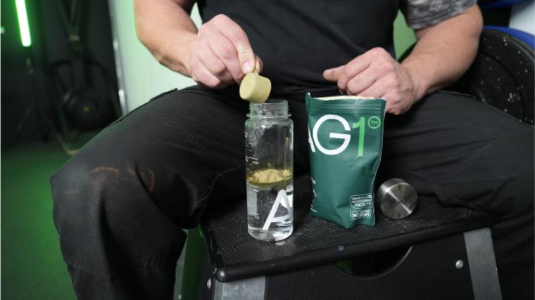 Our tester dumping a scoop of AG1 greens powder.