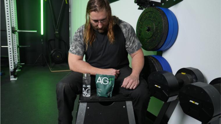 Our tester with AG1 in the BarBend gym.