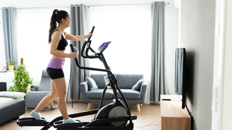 A fit person working out on an elliptical machine.