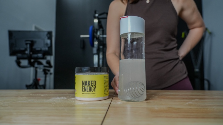 Our tester stands behind a bottle and container of Naked Pre.