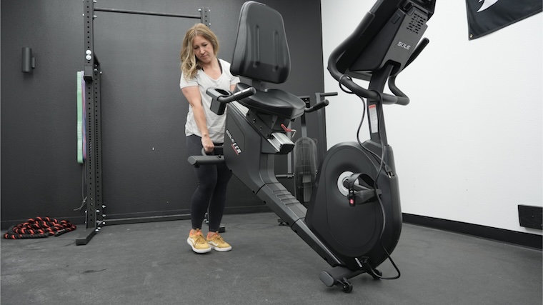 Our tester moving the Sole LCR Exercise Bike into position for a workout