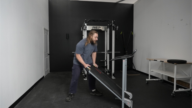 Our tester folding up the Sunny Health and Fitness Manual Treadmill.