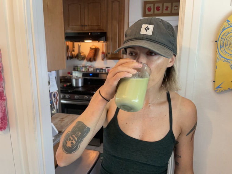 Our tester drinks a Truvani Plant-Based Protein Powder shake from a glass jar.