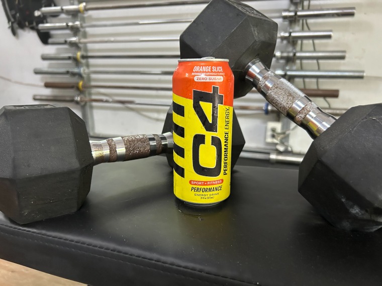 A can of C4 Energy Drink staged with dumbbells