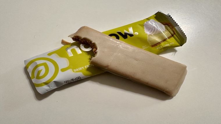 A No Cow Dipped Protein Bar with a bite taken out