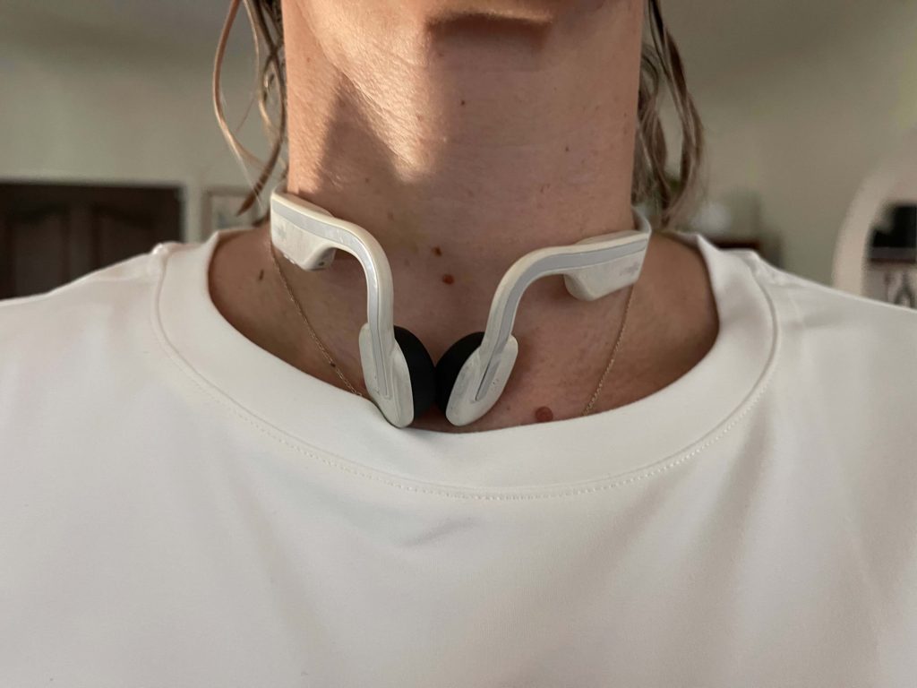 The SHOKZ Open Move headphones around the neck of our tester.