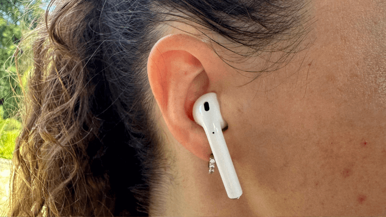 A person wearing a pair of Apple AirPods.