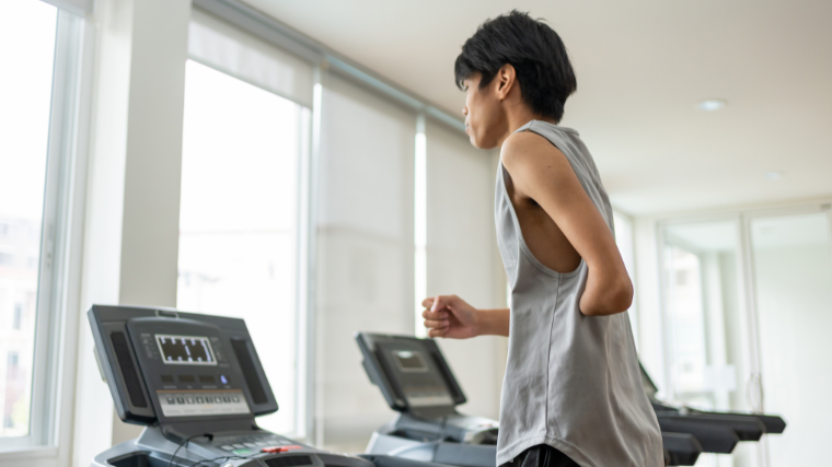An athlete runs on a treadmill in a fitness studio.