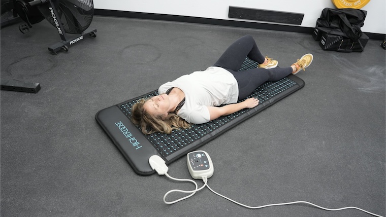 Our tester lies down on the HigherDOSE PEMF mat.