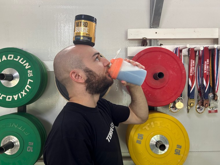 Our tester drinking Jacked Factory Nitro Surge while balancing the container on their forehead.