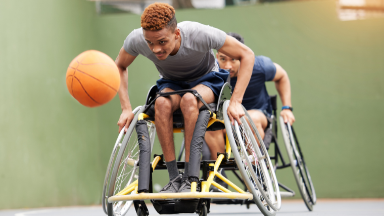 Two wheelchair users play an intense game of basketball.