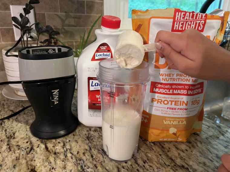 Pouring a scoop of Healthy Heights Grow Daily Protein Powder