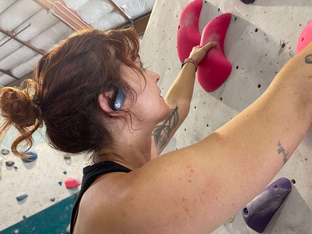 A BarBend tester climbing while wearing the Beats Powerbeats Pro headphones.