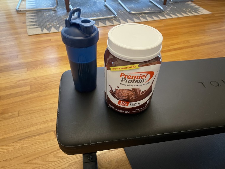 A Premier Protein Powder shake on a weight bench.