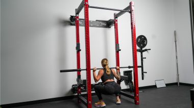 Our tester does a deep squat with a barbell racked on her back, using the PRx Pro Folding Cage Squat Rack.