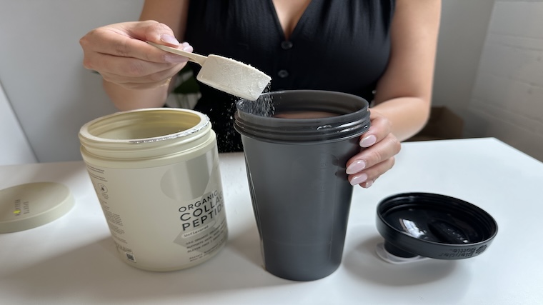 Our tester dumping a scoop of Sports Research Collagen Peptides into their shaker cup