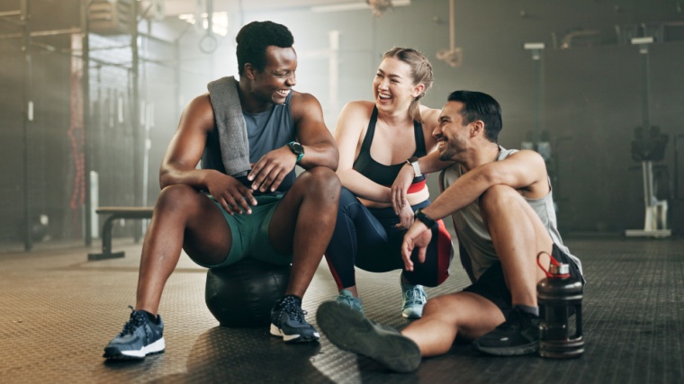 Three people talk after a group workout