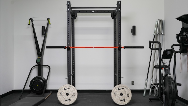 Nike Grind Bumper Plates sitting next to a squat rack