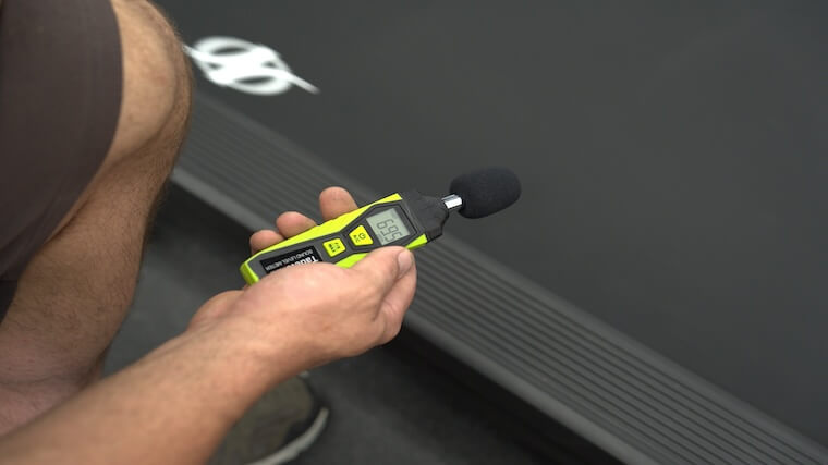 Our tester using a decibel reader to test the audio output of the NordicTrack Commercial 1750 treadmill