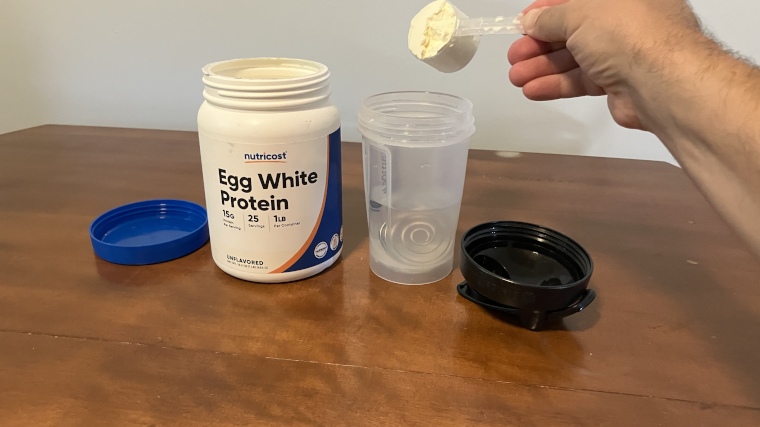 Our tester dumping a scoop of Nutricost Egg White Protein Powder