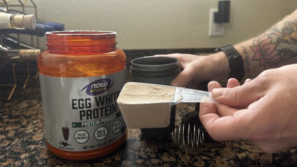 Our tester demonstrates the scoop size for Now Sports Egg White Protein