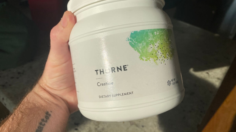 Our tester holds a tub of Thorne Creatine