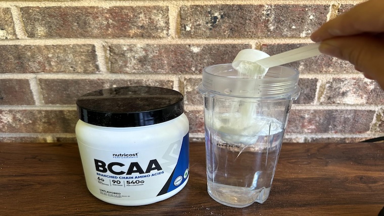 Our tester mixing a shaker cup of Nutricost BCAAs