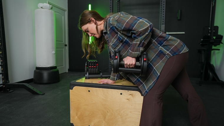 Our tester using the REP QuickDraw Adjustable Dumbbells for a row