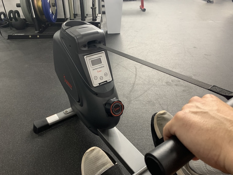 A person using the Sunny Health & Fitness SF-RW5801 Rowing Machine.