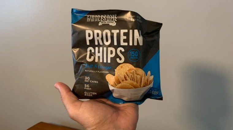 Our tester holding a bag of Wholesome Provisions Protein Chips.