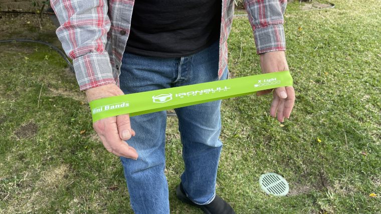 A man exercises with an Iron Bull Mini Band