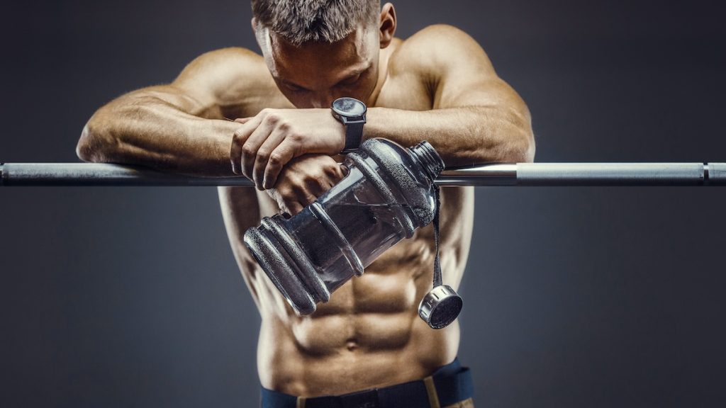 Male athlete holding water bottle.